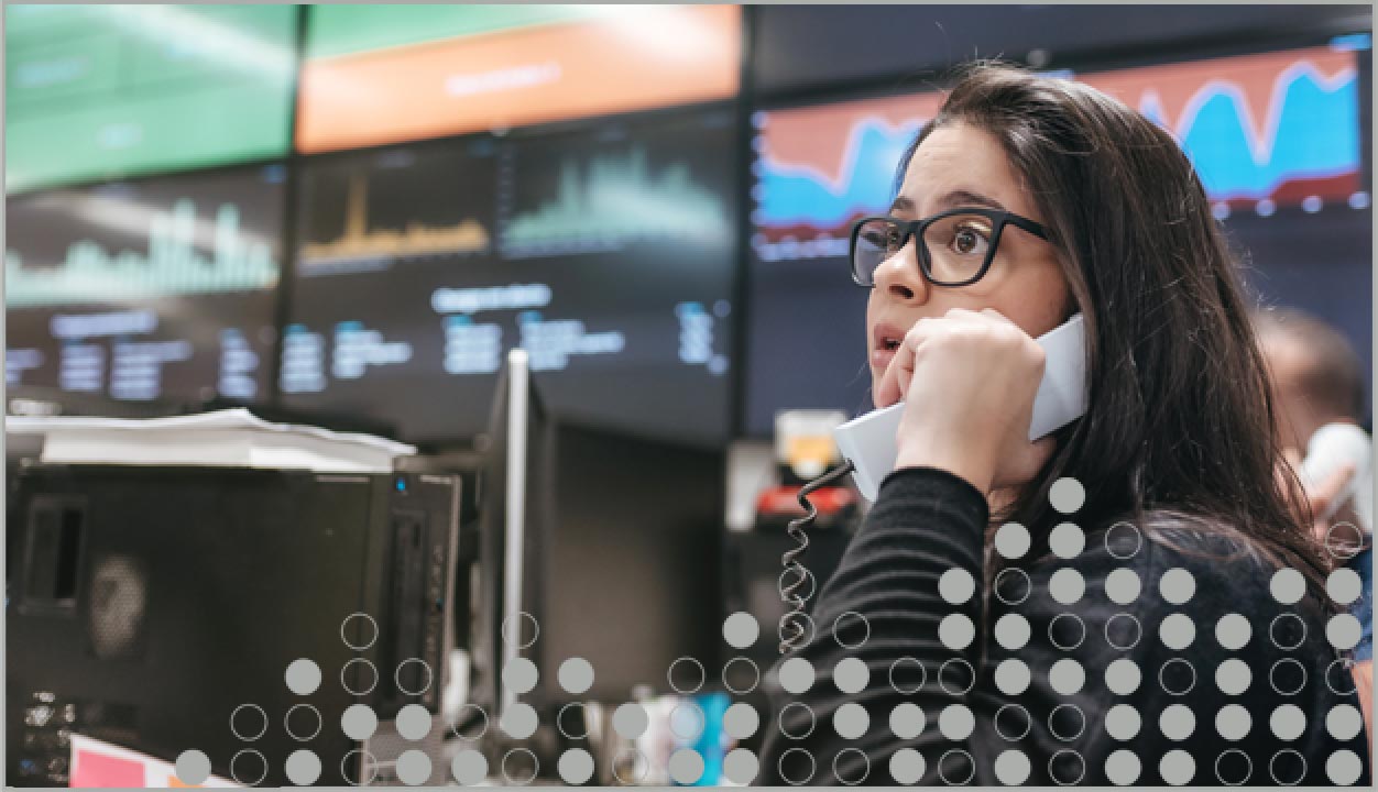 woman on phone stock market screens