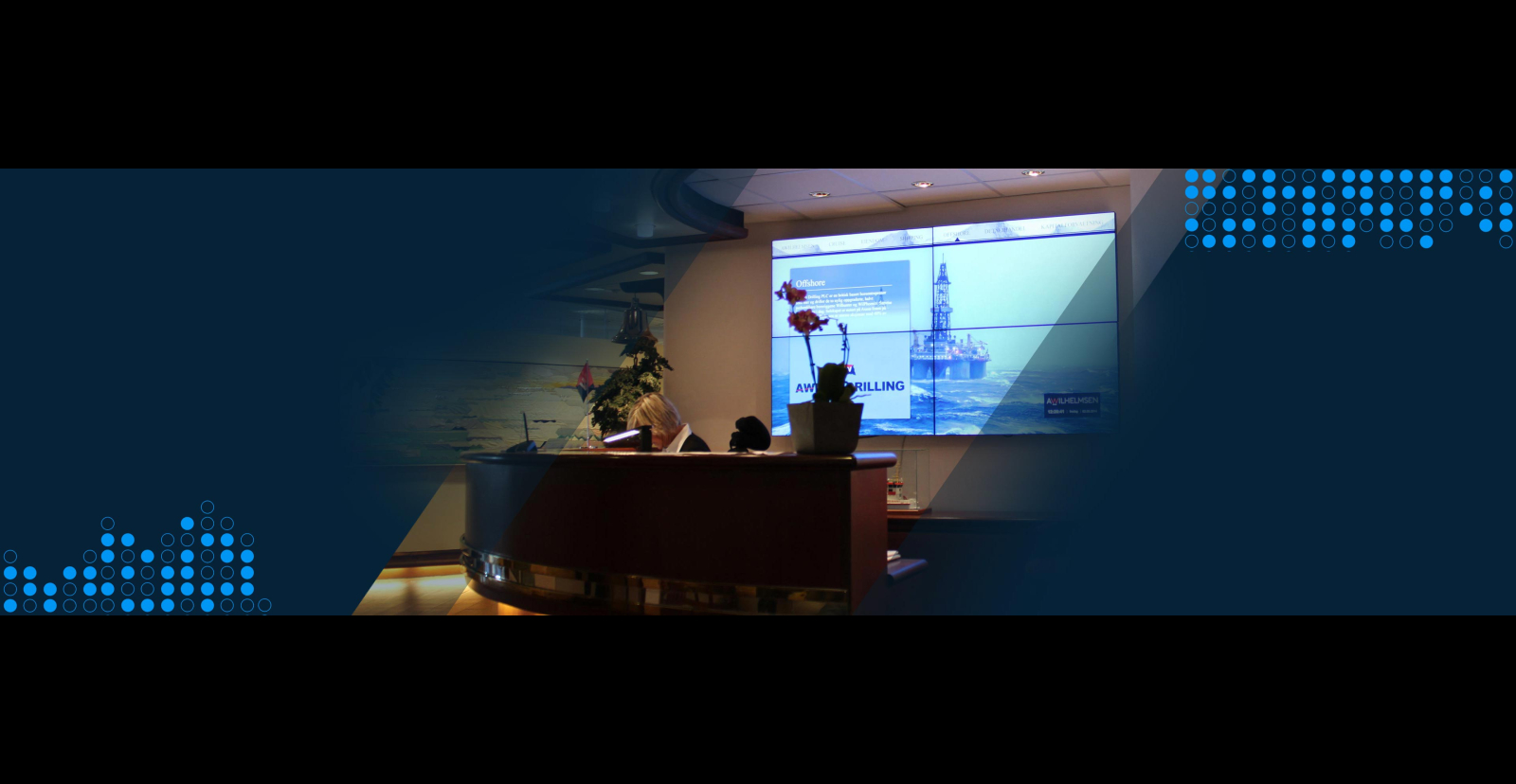 A corporate reception desk with digital signage behind
