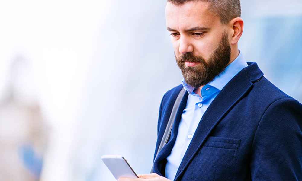 a man in a suit looking at his phone screen